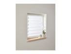 White zebra blinds on a window with a wooden sill, decorated with a plant and mug.