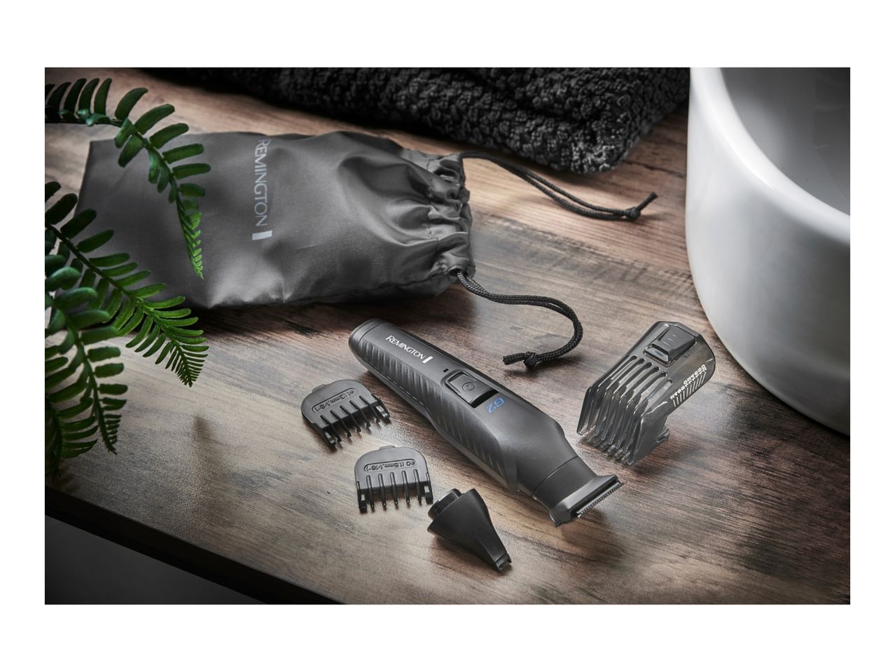 Remington G2 grooming kit with accessories on a wooden surface next to a sink.