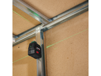 Nível laser de linhas cruzadas PARKSIDE PERFORMANCE projetando linhas verdes numa parede de madeira e estruturas metálicas.