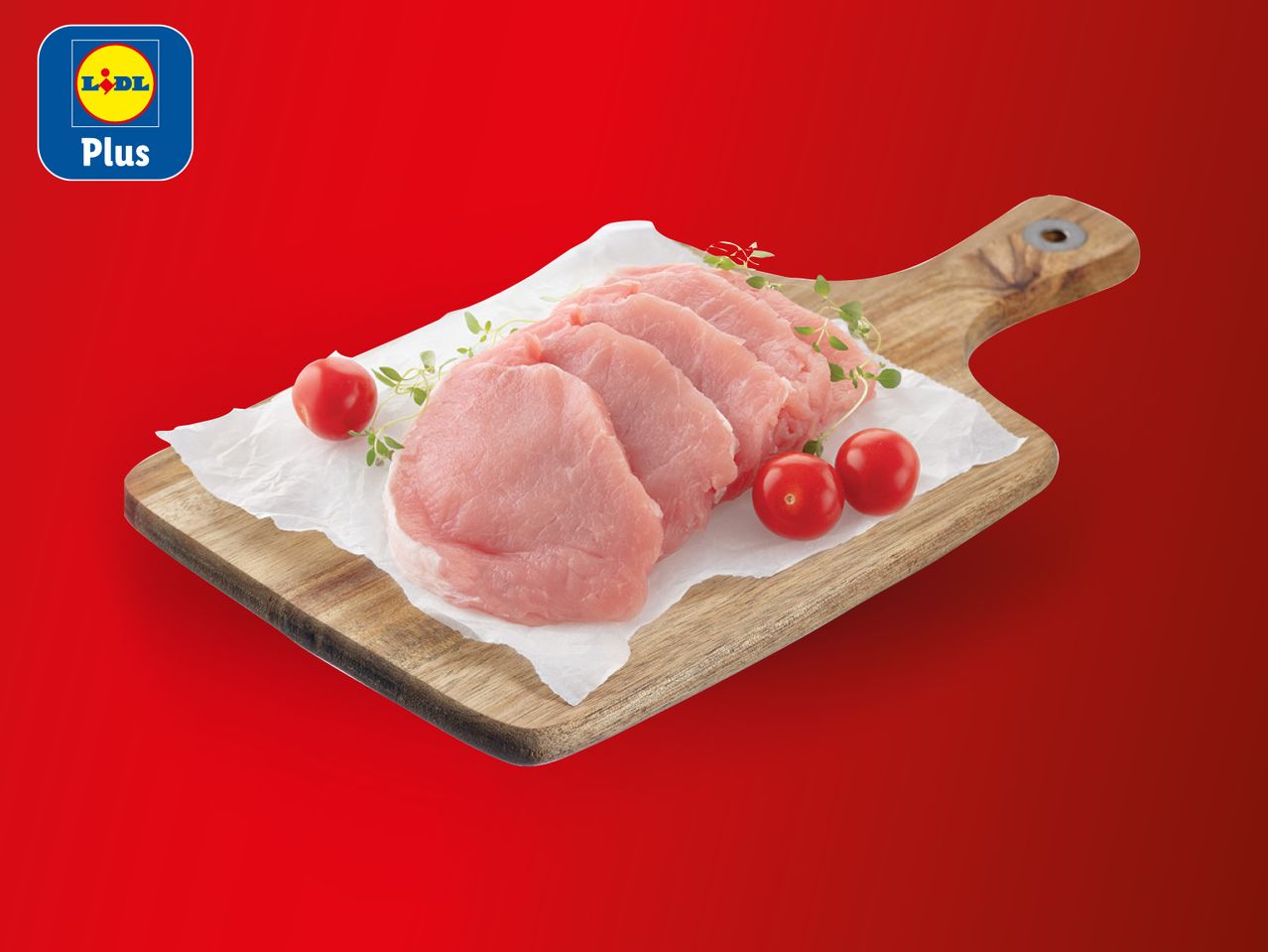 Svinjski odresci na dasci za rezanje s rajčicama i začinskim biljem, s logotipom Lidl Plus.