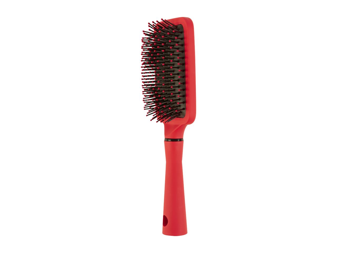 A red paddle hairbrush with black bristles stands upright against a white background.