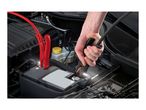 A person jump-starting a car battery with red and black jumper cables.