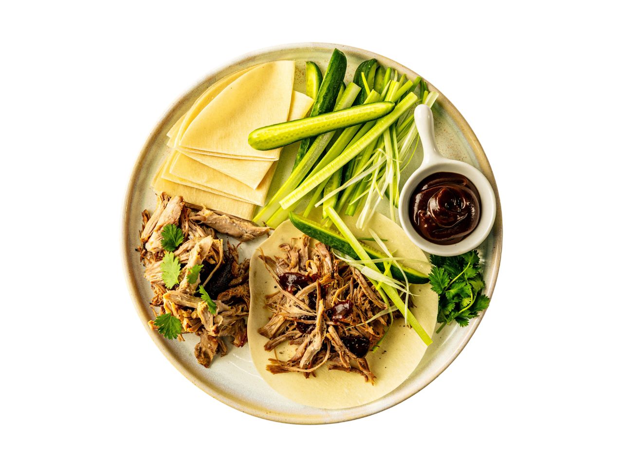 Peking duck pancakes with shredded duck, cucumber, spring onion, and hoisin sauce.