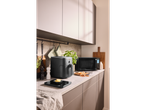Un air fryer negru și un cuptor cu microunde pe un blat de bucătărie modern.