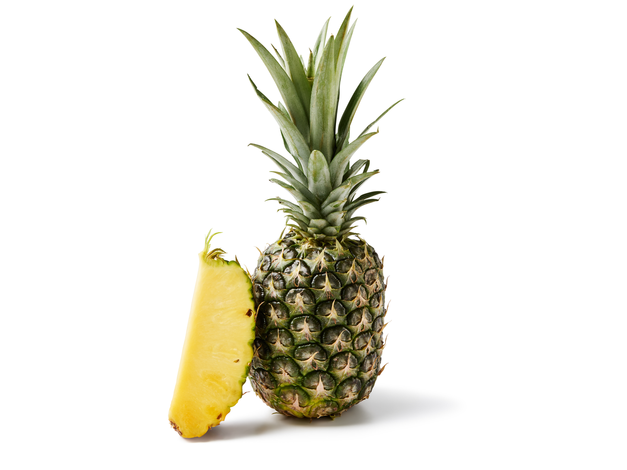 Hele ananas met een plak ernaast