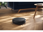 Aspirator robot SILVERCREST® curățând o podea de lemn într-un living însorit.