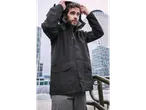 Man wearing a dark Esmara raincoat, adjusting the hood, with city buildings in the background.