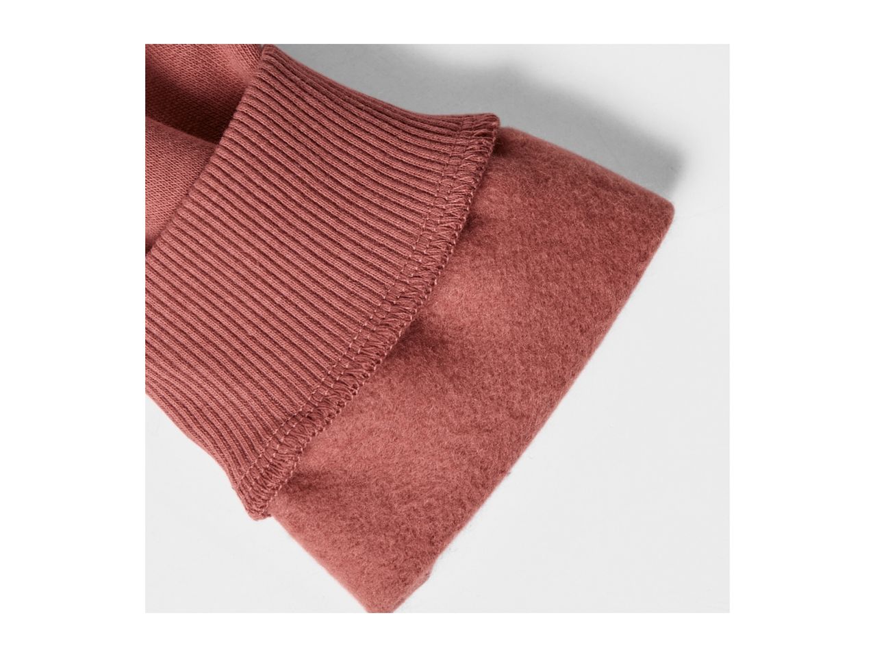 Close-up of a folded, ribbed, and fuzzy fabric in a dusty rose color.