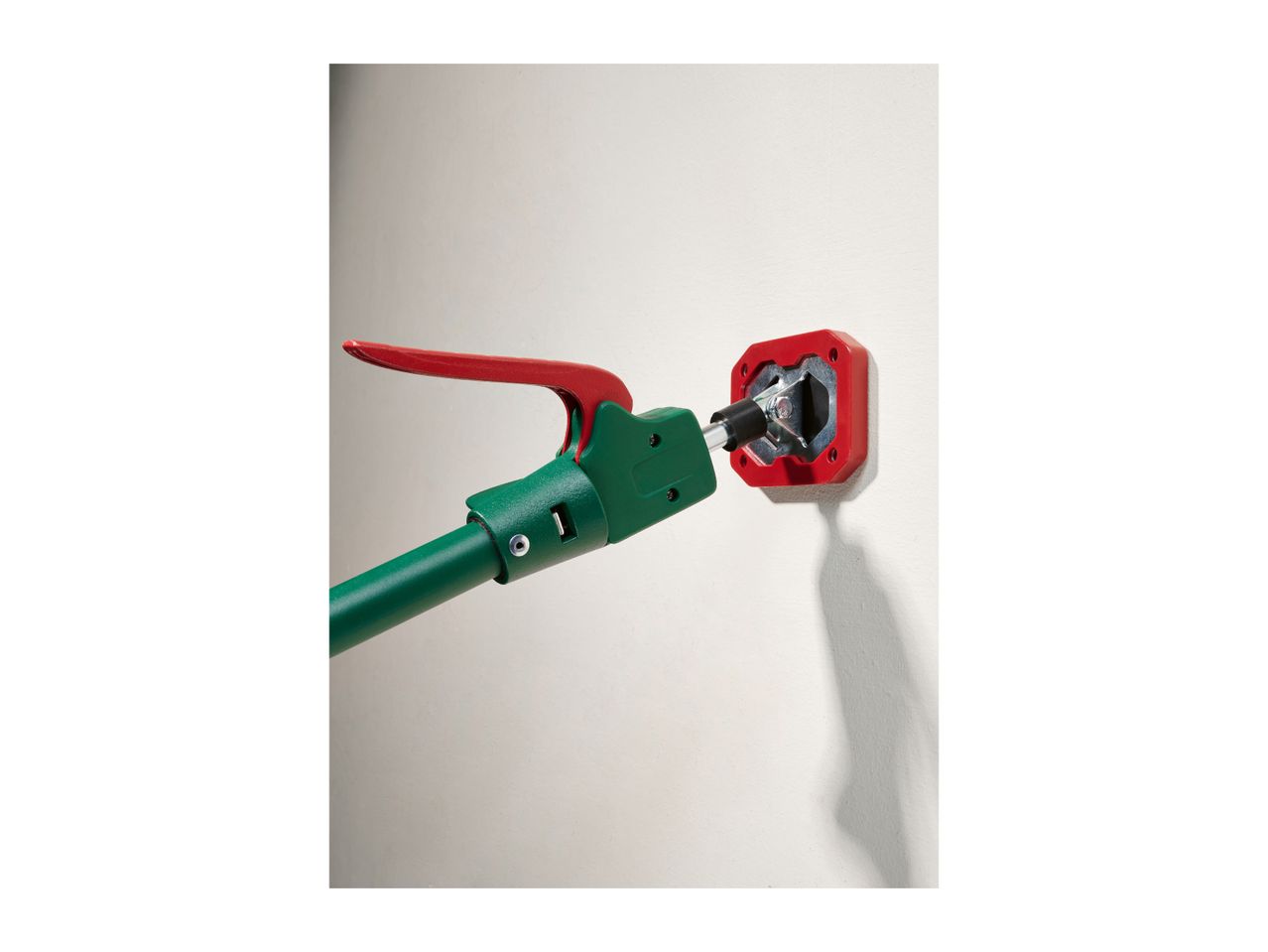 Green and red tool connecting to a red wall-mounted socket.