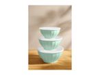 Stack of three mint green mixing bowls with white lids on a wooden surface.