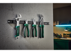 Parkside tools, including a wrench and pliers, hanging on a magnetic strip in a workshop.