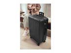 A black suitcase with a person holding a cup of coffee in the background.