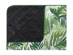 Folded picnic blanket with a tropical leaf pattern on one side and a black quilted underside.