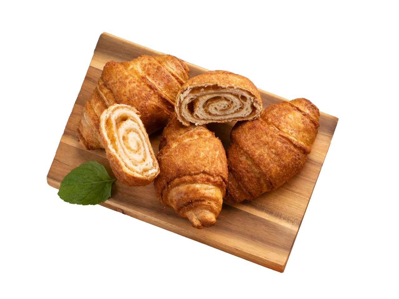 Croissant-ok és fahéjas csigák fa deszkán.