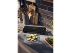 Máquina de vácuo Silvercrest® na bancada da cozinha com curgete em sacos de vácuo.