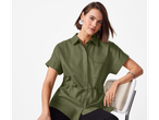 Modelo vestindo uma camisa verde-oliva de linho com mangas curtas.