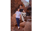 Man in light blue shirt and navy trousers, woman in black top and patterned trousers in a canyon.