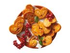 Heart-shaped puff pastry cookies with sugar, red currants, and mint on a plate.