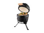 Black ceramic grill with an open lid, grilling sausages, steak, and vegetable skewers.