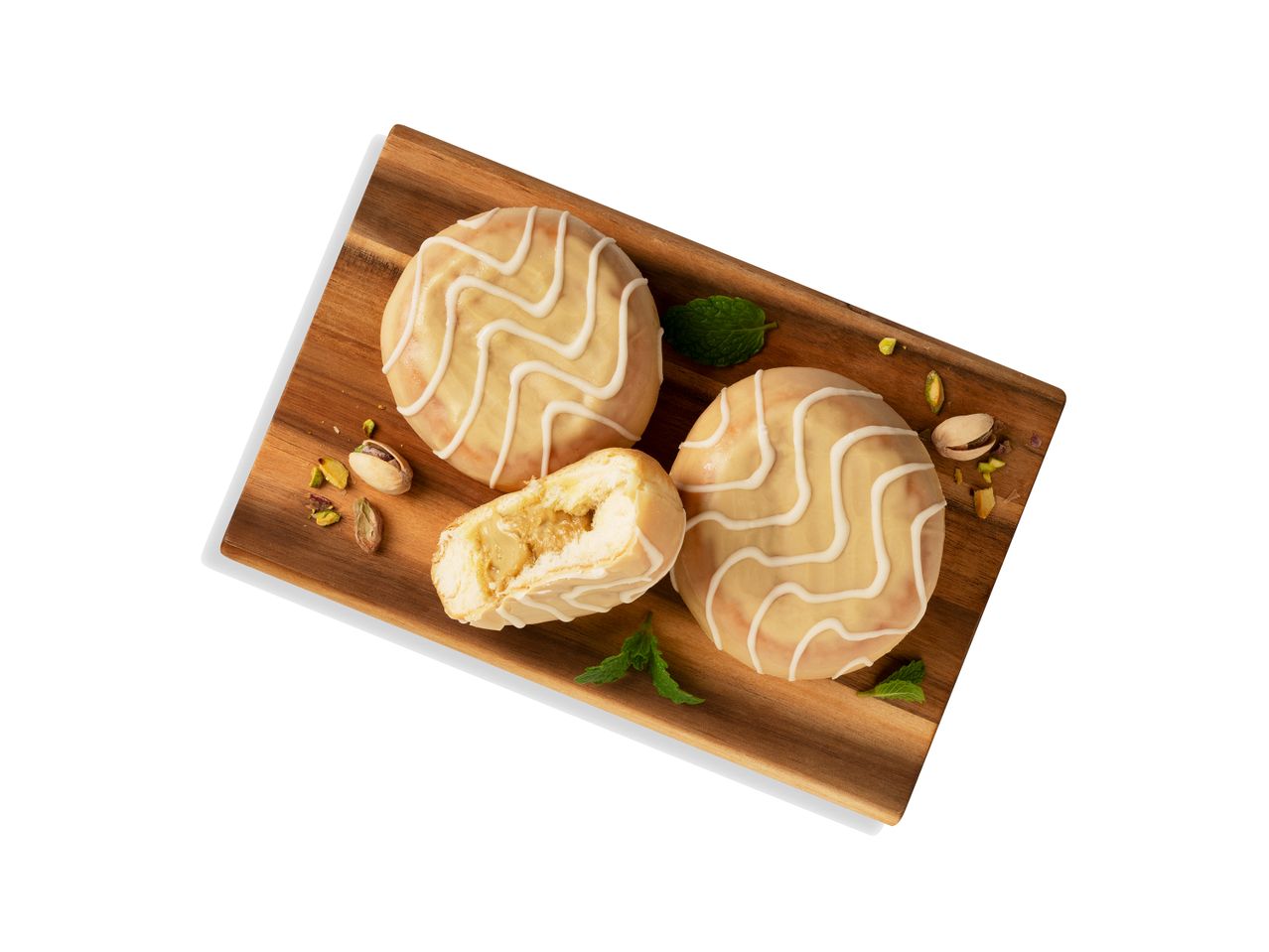 Pisztáciás sütemények mázzal fából készült táblán.