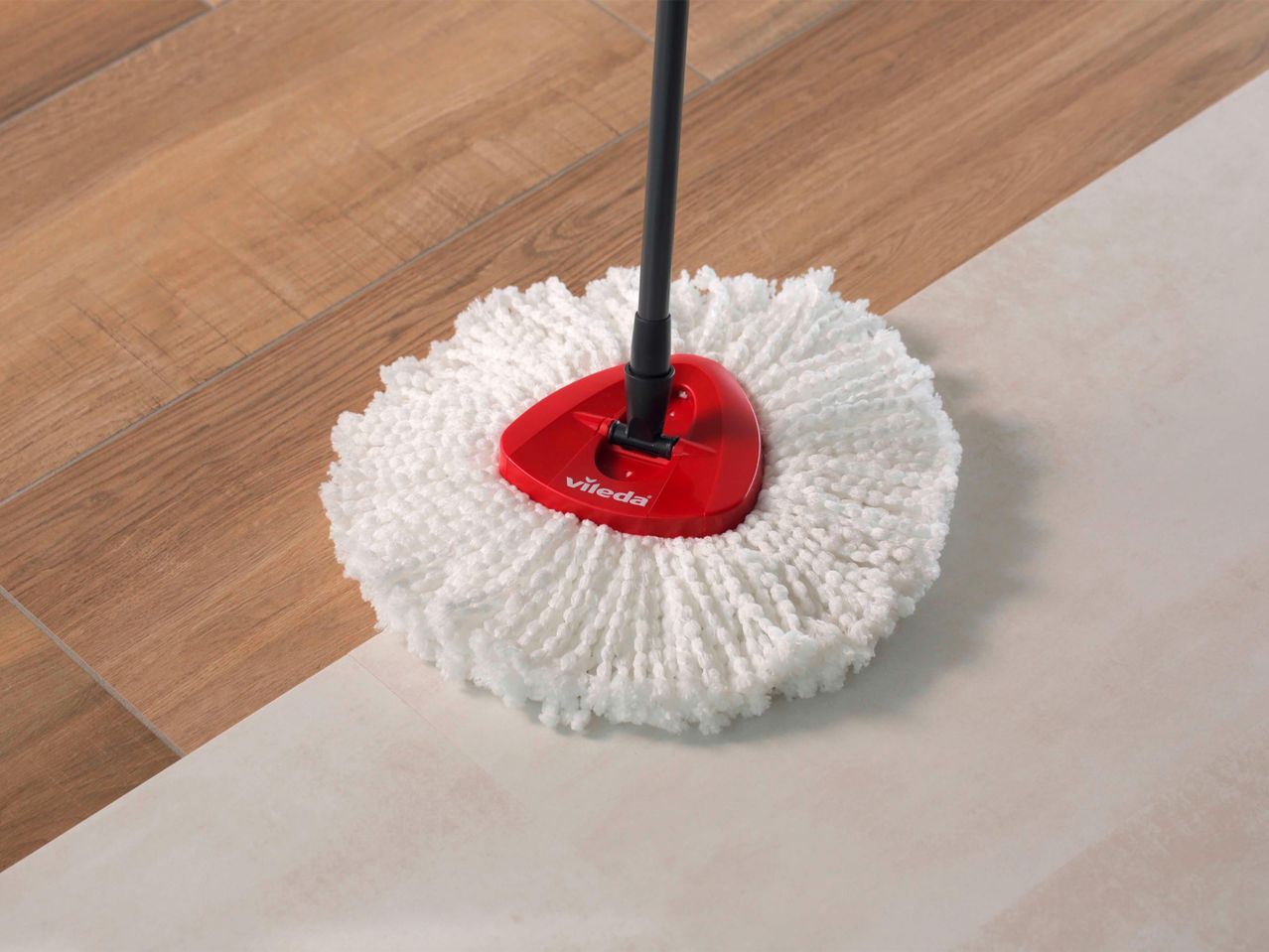 Vileda felmosófej fehér mikroszálas felmosóval, amely fapadlót és világos csempét tisztít.
