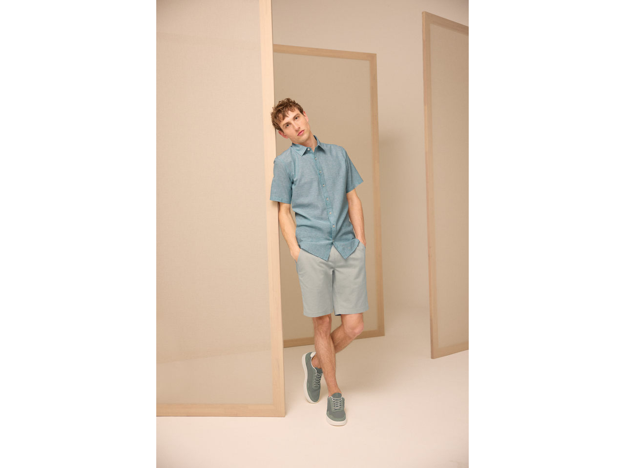 Homem com camisa azul, calções azul-claros e sapatilhas cinzentas ESMARA MEN.