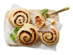Cinnamon rolls with pearl sugar and mint on a wooden board with a fork.