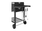 Black charcoal grill with side shelf and hanging barbecue tools.