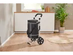 Cărucior de cumpărături negru cu roți într-un mediu de bucătărie modern.
