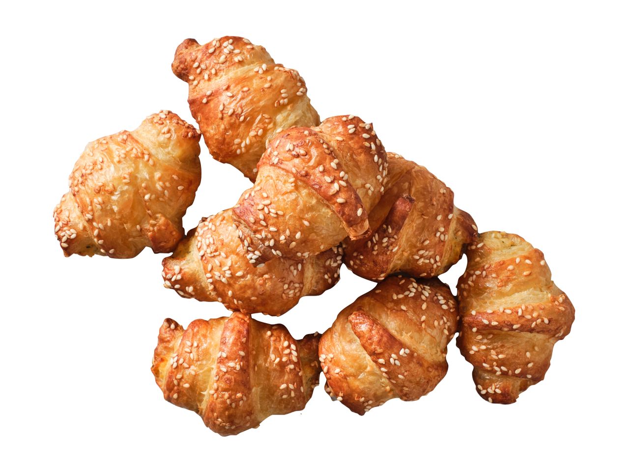 Kuhjas kuldsed seesamiseemnetega sarvesaiad valgel taustal.