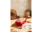 A marbled cake in a red SILVERCREST® silicone loaf pan on a wooden counter.