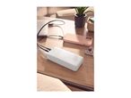 White power bank charging a laptop and a pink smartphone on a wooden table.