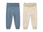 Zwei Babyhosen: eine blaue und eine gestreifte in Beige und Weiß