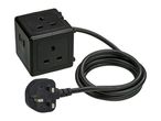 Black cube-shaped power strip with three UK sockets and a coiled power cable with a UK plug.