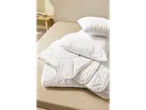 Fluffy white pillows and duvet on a bed.