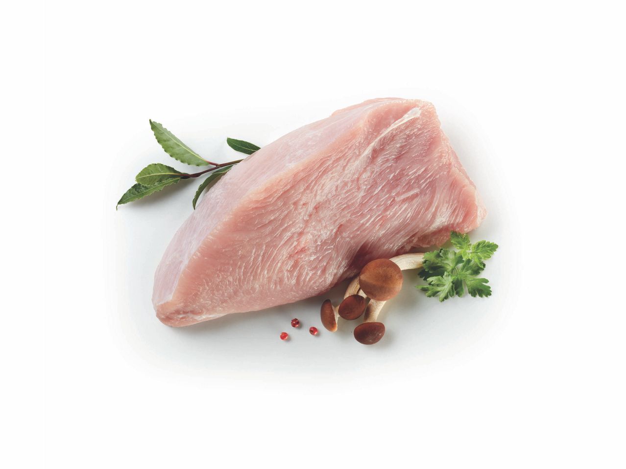 Fesa di tacchino cruda con funghi, prezzemolo e bacche rosa su sfondo bianco.