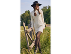 Woman in an esmara® ladies' jumper dress and hat, leaning on a wooden fence.