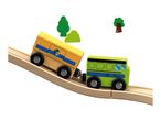 Wooden toy train with yellow and green carriages on a track with trees.