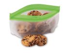 Chocolate chip cookies in a reusable silicone bag, with two cookies in front.