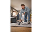 Man and woman using a SILVERCREST® 20V Cordless Spot Cleaner on a rug and sofa.