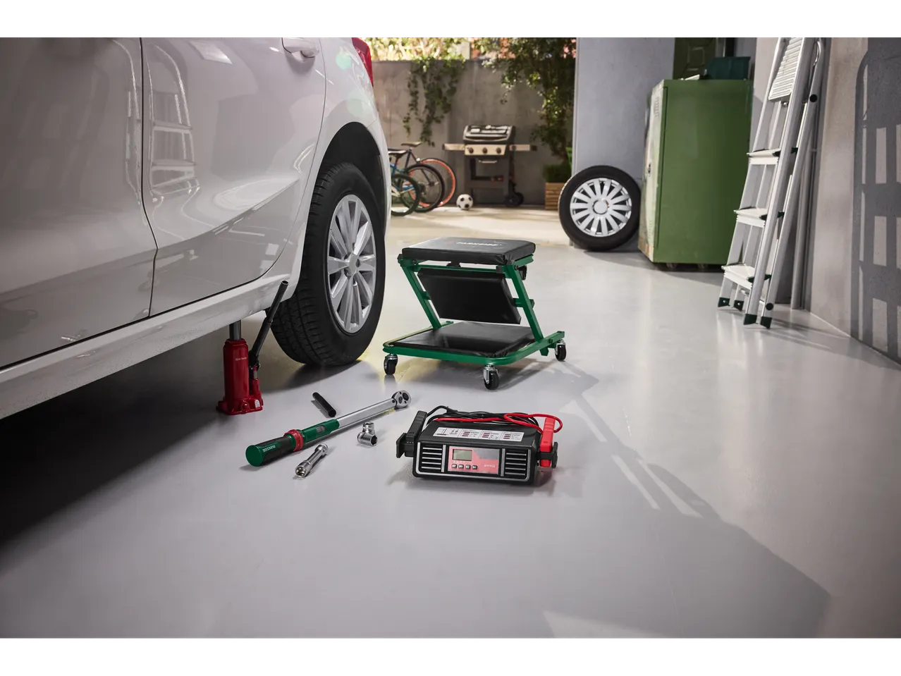 Încărcător de baterii Ultimate Speed® și unelte de întreținere auto într-un garaj.