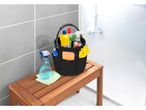 Organizer portaoggetti nero con prodotti per la pulizia in un bagno.