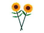 Two toy sunflowers with yellow petals, brown centers, and green stems.