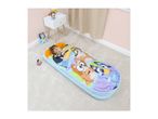 Child sleeping in a colorful character sleeping bag on a carpeted floor with toys nearby.