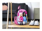 Pink backpack with two dolls and light blue sneakers on a wooden shelf.