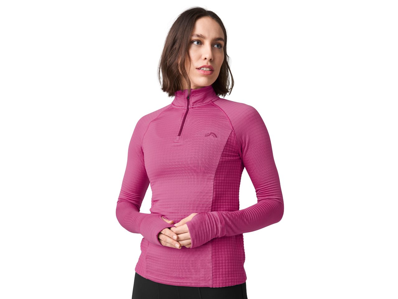 A woman in a pink long-sleeved athletic top with a quarter-zip and thumbholes.