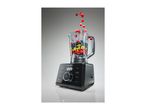 A modern black blender filled with fresh fruit and berries falling into the jar.