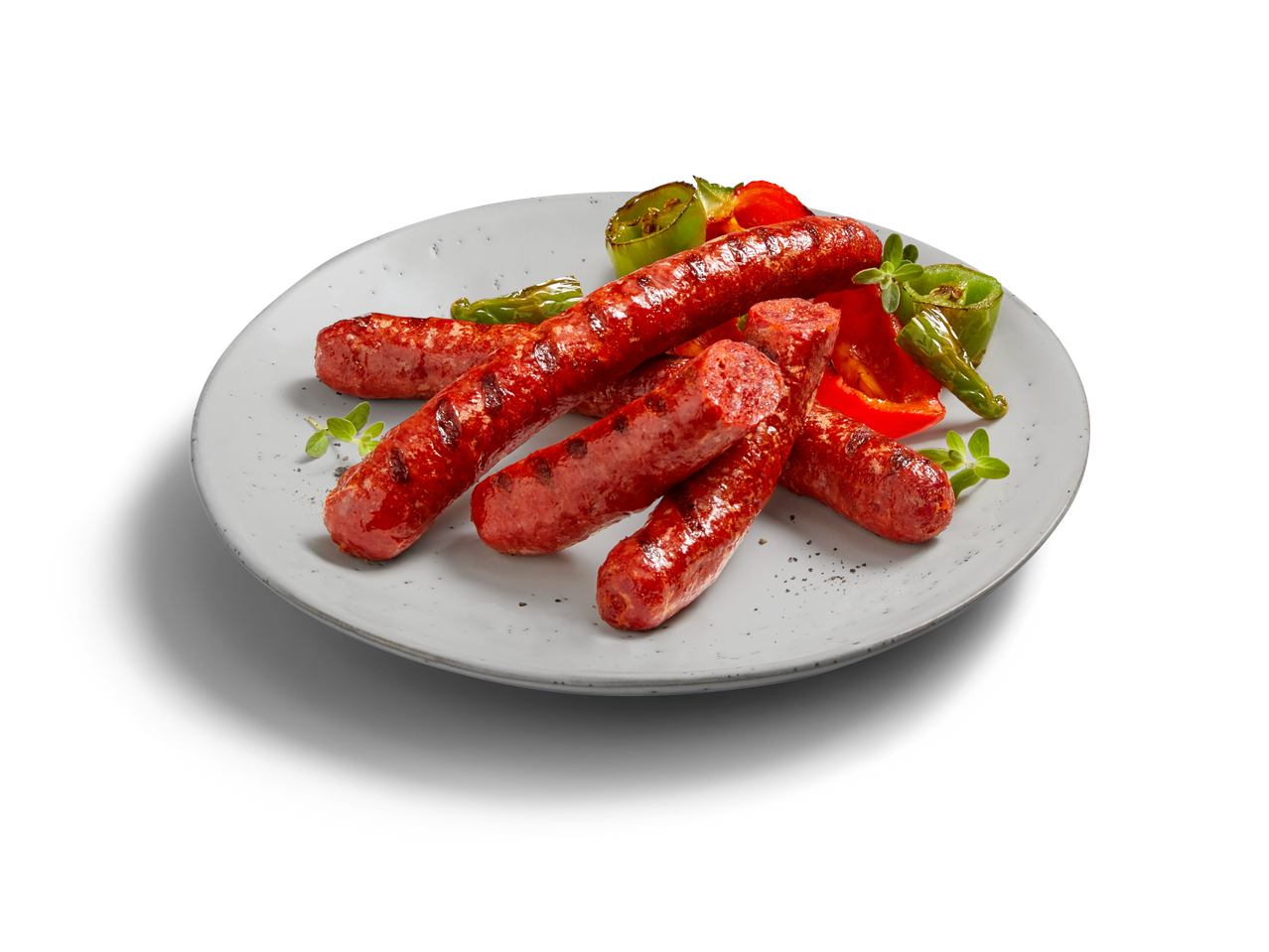 Gegrillte Würstchen mit Paprika und Kräutern auf einem Teller.