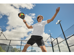 Homem com roupa desportiva CRIVIT, raquete de padel na mão, num campo exterior.