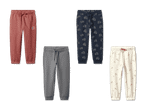 Vier Paar Jogginghosen: eine rote mit Sonne, eine graue, eine blaue mit Traktoren und eine cremefarbene mit Blumen.